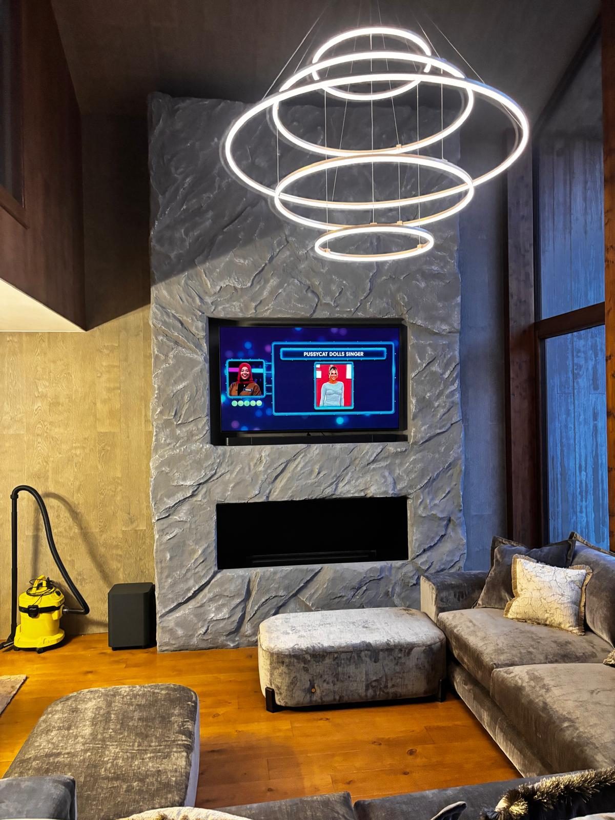 Grey stone fireplace with chandelier